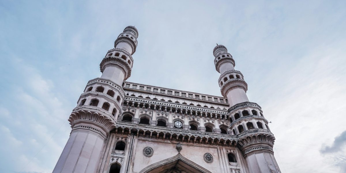 low angle photography of gray concrete building under white clouds during daytime